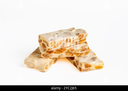 Several portions of hard almond nougat in close-up and on a white background. Stock Photo