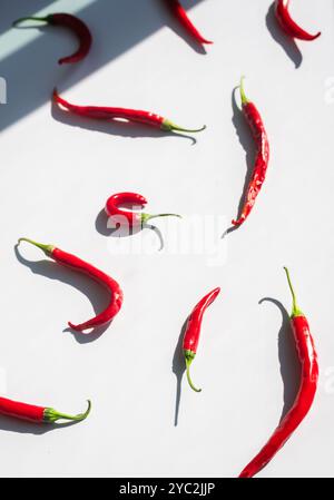 Scattered fresh red chilies on a white background. Stock Photo