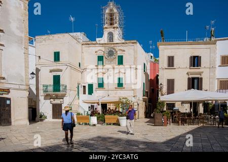 Polignano a Mare Italy 18 September 2024, Visitors stroll through a picturesque square in Puglia, enjoying the vibrant atmosphere, quaint cafes, and b Stock Photo