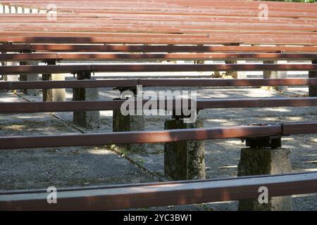 View of old-fashioned wooden benches in an outdoor amphitheater - abstract patterns from benches and a concrete floor. Benches are arranged in rows, c Stock Photo