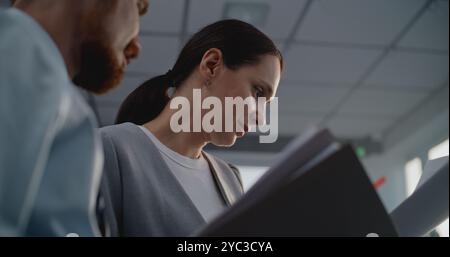 Portrait of two financial specialists or marketing professionals studying documents, discussing strategy of company, brainstorming project ideas. Corporate business partners work in modern office. Stock Photo