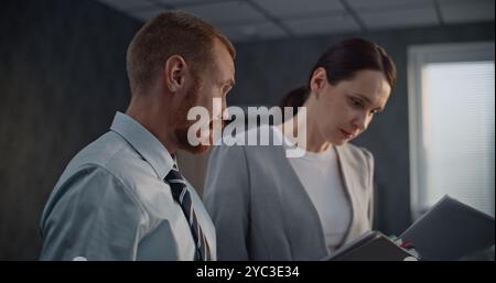 Brainstorming in modern office of international company: Male and female colleagues, financial specialists analyze papers, discuss project ideas, develop business strategy. Marketing, banking system. Stock Photo