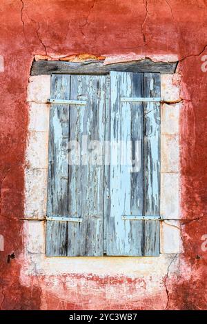 Rustic wooden shutters and red wall Stock Photo