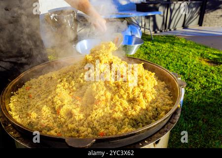 Large cast iron cauldron, during cooking cuisine traditional is Turkish pilaf Stock Photo