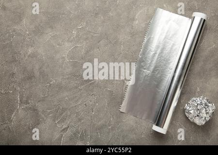 Foil ball with aluminium rolls on grey background. Top view Stock Photo