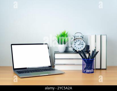 Laptop with blank screen on white table and office supplies on wooden background. Space for copying your text. Workspace and copy space. Desk with off Stock Photo