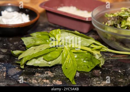 Photo of a bunch of fresh basil on a chopping board ready to be used in a cooking dish Stock Photo