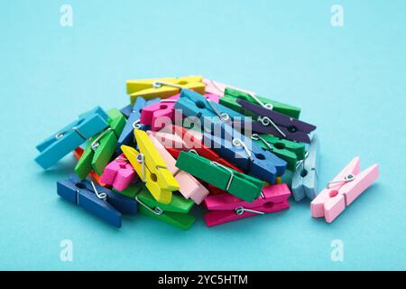 Colored wooden clothespins on blue background. Design elements. Macro. Space for text Stock Photo