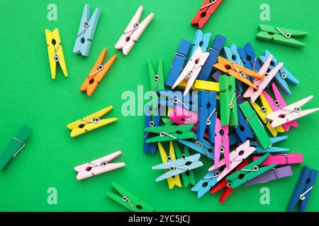 Colored wooden clothespins on green background. Design elements. Macro. Space for text Stock Photo