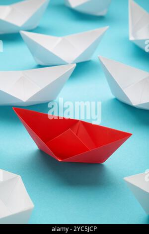 Leadership concept. Red leader paper ship leading among white on blue background. Top view Stock Photo