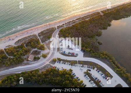 Parking lot for tourists cars in front of ocean beach with soft white sand in Florida. Popular vacation spot at sunset. Stock Photo