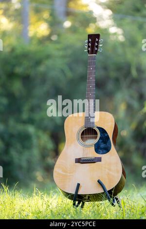 Acoustic guitar outdoors on greenery background. Concept of calm music. Stock Photo