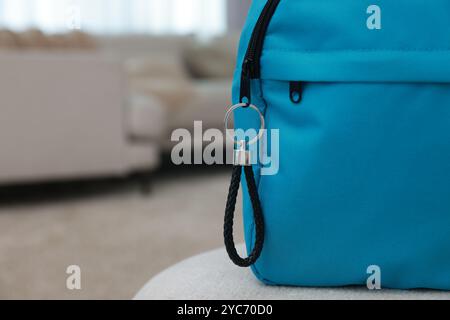 Backpack with black leather keychain on soft surface indoors, closeup. Space for text Stock Photo