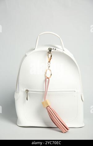 Backpack with pink leather keychain on grey background Stock Photo