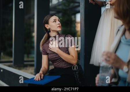 Young woman attentively listening during outdoor meeting Stock Photo