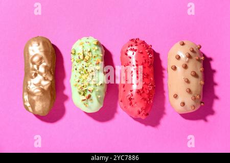 Delicious glazed eclairs on pink background Stock Photo