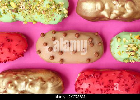 Composition with tasty glazed eclairs on pink background Stock Photo