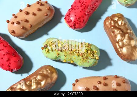 Composition with various glazed eclairs on color background Stock Photo