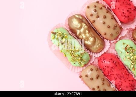 Composition with different glazed eclairs on pink background Stock Photo
