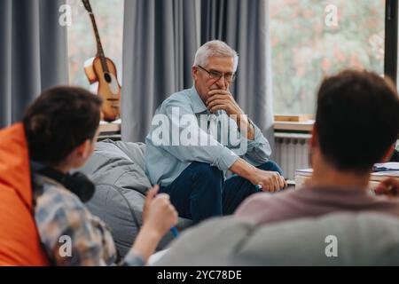 Professor engaging with students in a thoughtful discussion Stock Photo