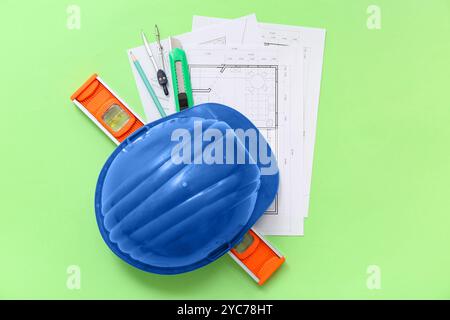 Architect's supplies with house plans on green background Stock Photo