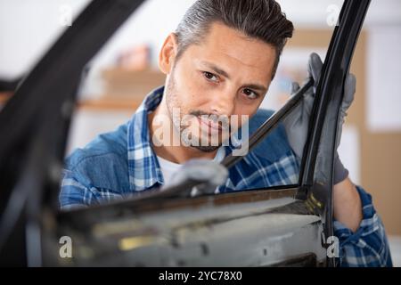 male mechanic fitting rubber on car door Stock Photo