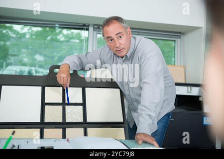 male interior designer showing colour wheel to clients Stock Photo