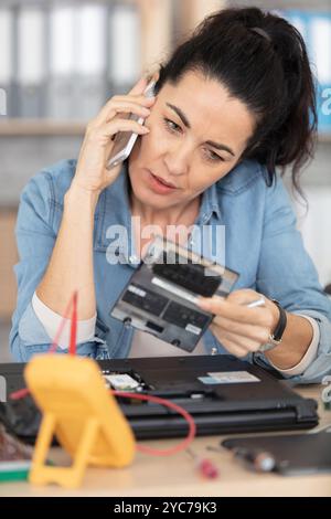 engineer repairs laptop in her workshop Stock Photo