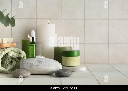 Burning candles, cosmetics and spa supplies on light background Stock Photo