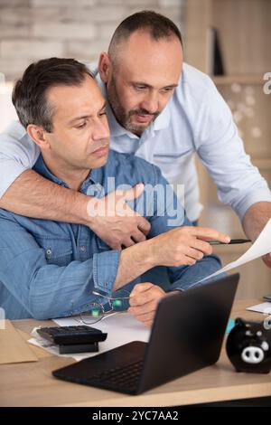 homosexual men looking at paperwork in the home Stock Photo