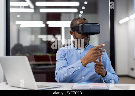 African American mature businessman in office using virtual reality headset for demonstration. Innovating with technology in corporate setting, enhanc Stock Photo
