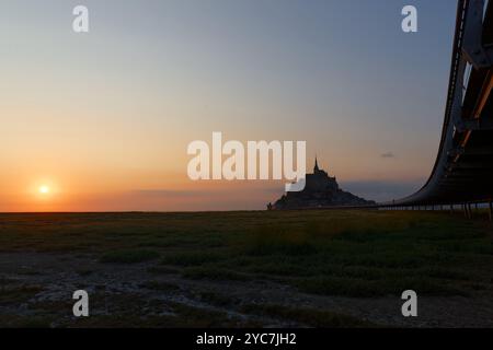 Dramatic sunset over the famous Mont Saint-Michel, a town located in Normandy west of Paris on the small island near the riverside. Stock Photo