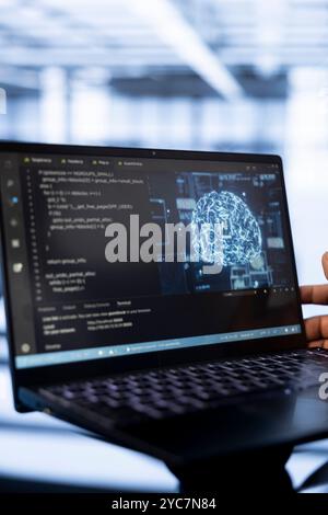 Computer scientist using laptop in data center, updating AI systems. Close up shot of device used by server room worker upgrading artificial intelligence simulation model Stock Photo