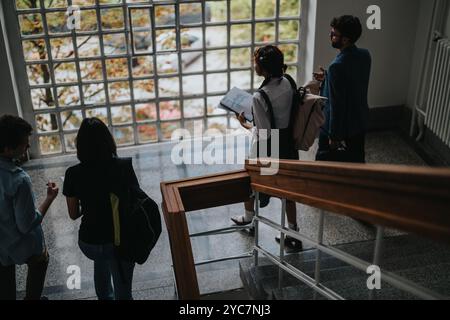 Students discussing study plans while walking down the stairs Stock Photo