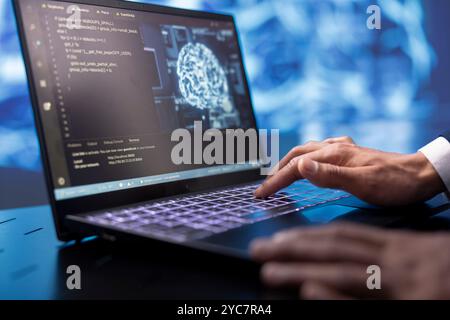 System administrator running AI cognitive computing tech on laptop to simulate computerized model. Close up of notebook used by IT specialist to do data mining with artificial intelligence Stock Photo
