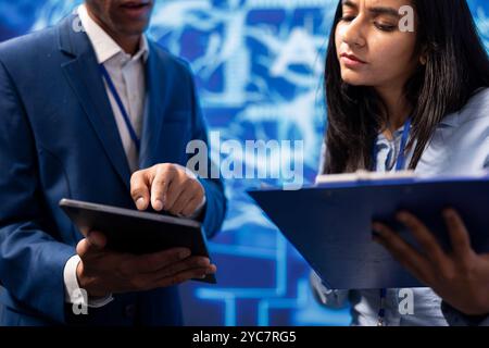 Developer and colleague analyzing complex AI brain models on tablet. IT specialist and coworker using machine learning software on device to develop artificial intelligence technology Stock Photo