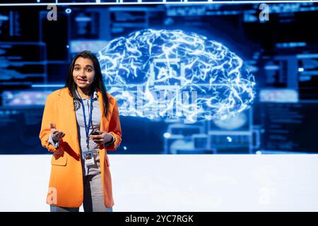IT professional holding presentation exploring ways emerging AI technologies can enhance businesses workforce. Computer scientist at event presents strategies for using artificial intelligence Stock Photo