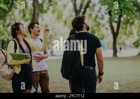 Multicultural students collaborating outdoors on school projects in a park setting Stock Photo
