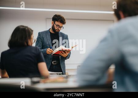 Professor assisting students in a classroom setting during a lesson Stock Photo