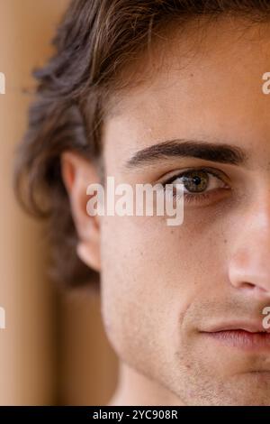 Close-up of young man with thoughtful expression, focusing on his eye, at home Stock Photo