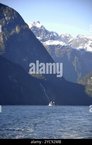 Tourist launch dwarfed by mountains at Milford Sound, Fiordland, New Zealand, Oceania Stock Photo