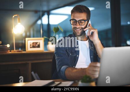 Night, office and man with phone call, laptop and paperwork for research report at digital agency. Late, plan and creative consultant with smartphone Stock Photo