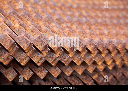 Perforated rusty metal floor sheet stamping plates texture closeup angled view. Metal stamping sheet metal manufacturing lightweight bearing flooring Stock Photo