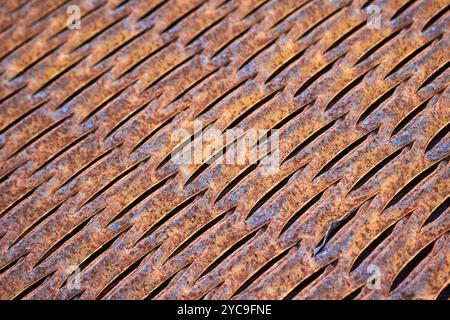 Perforated rusty metal floor sheet stamping plates texture closeup angled view. Metal stamping sheet metal manufacturing lightweight bearing flooring Stock Photo