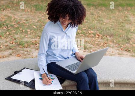 female entrepreneur working remotely in park Stock Photo