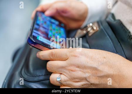 Hands of a woman playing a game on her smartphone. Stock Photo