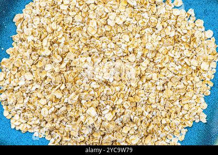 A pile of raw oatmeal on a blue plate. Stock Photo