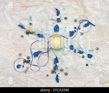 Various Christmas decorations arranged in the shape of a snowflake. Top view, marble table. Stock Photo