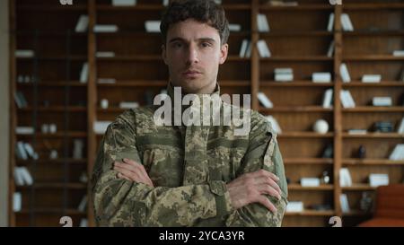 Confident strong young Caucasian male officer man guy in camouflage Ukraine uniform military army soldier patriot crossing arms cross hands serious Stock Photo