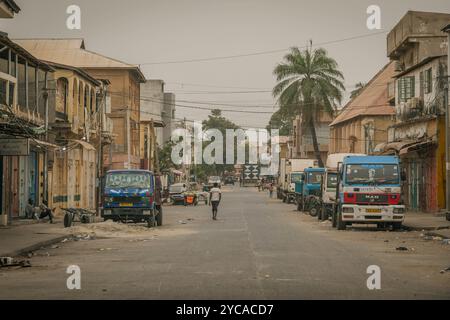 The empty streets of Banjul, with trash on the road and old African cars, at Gambia, West Africa. Stock Photo